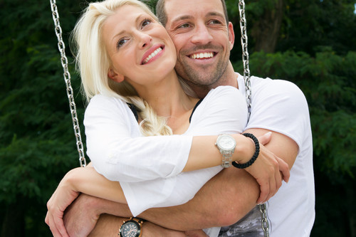 Glückliches Paar auf einer Schaukel im Freien.